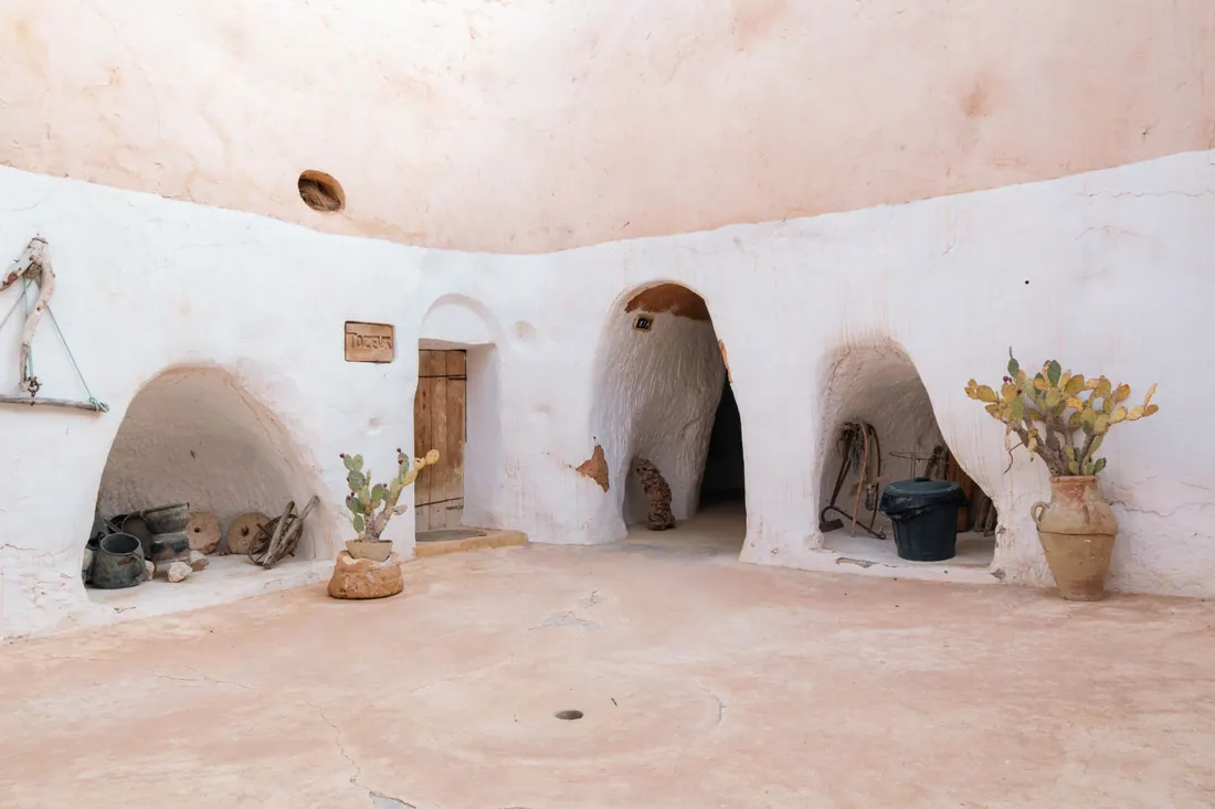 Casa rural de piedra con ventanas de madera en un entorno de campo