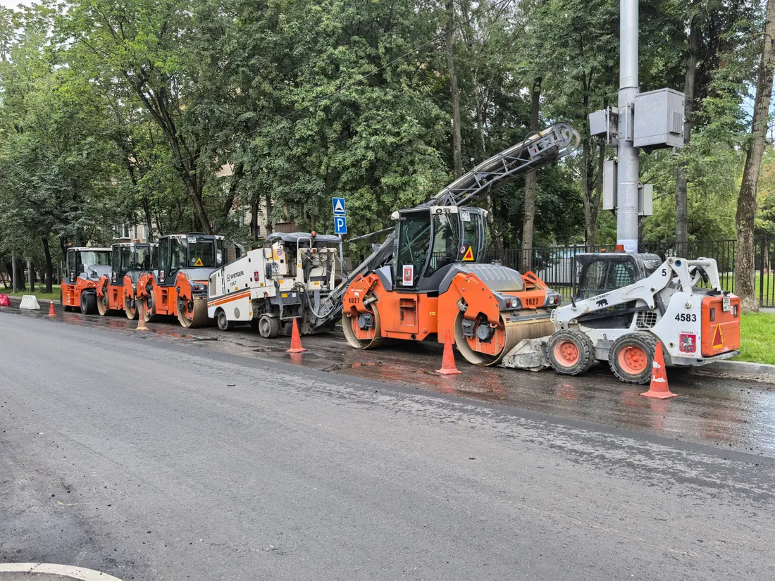 Calle urbana con vallas de obra y asfalto recién extendido