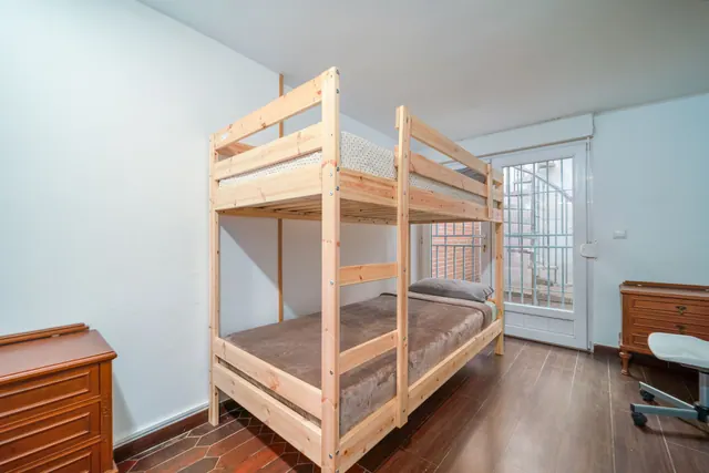 Litera de madera en un dormitorio con escritorio