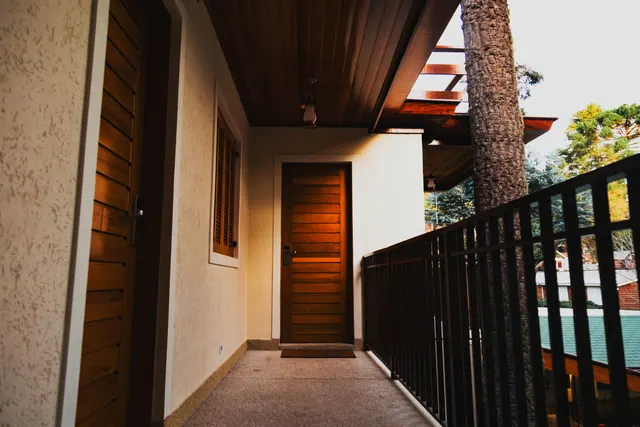 Pasillo exterior con puertas de madera en una vivienda