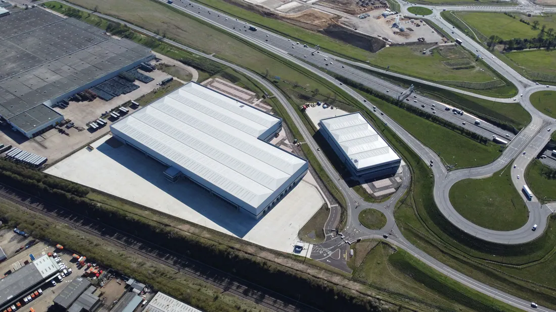 Vista aérea de naves industriales junto a una autopista y una rotonda