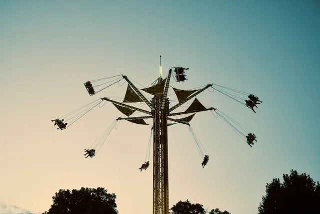 Atracción de feria de sillas voladoras al atardecer