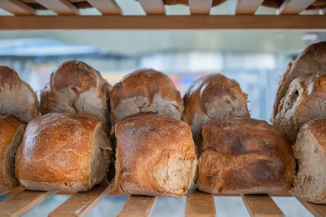 Varias barras de pan recién horneadas en un estante de panadería