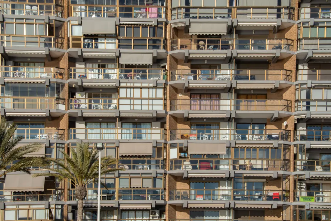 Fachada de un edificio de apartamentos con balcones y toldos