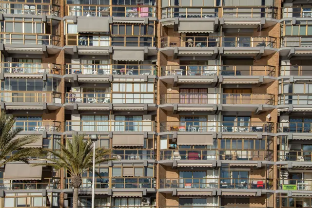 Fachada de un edificio de apartamentos con balcones y toldos